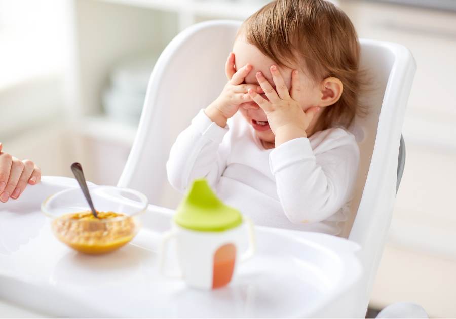 toddler sitting in high chair and refusing to eat