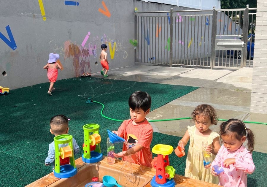 toddlers playing with water toys in yard toddlers playing with water toys in yard
