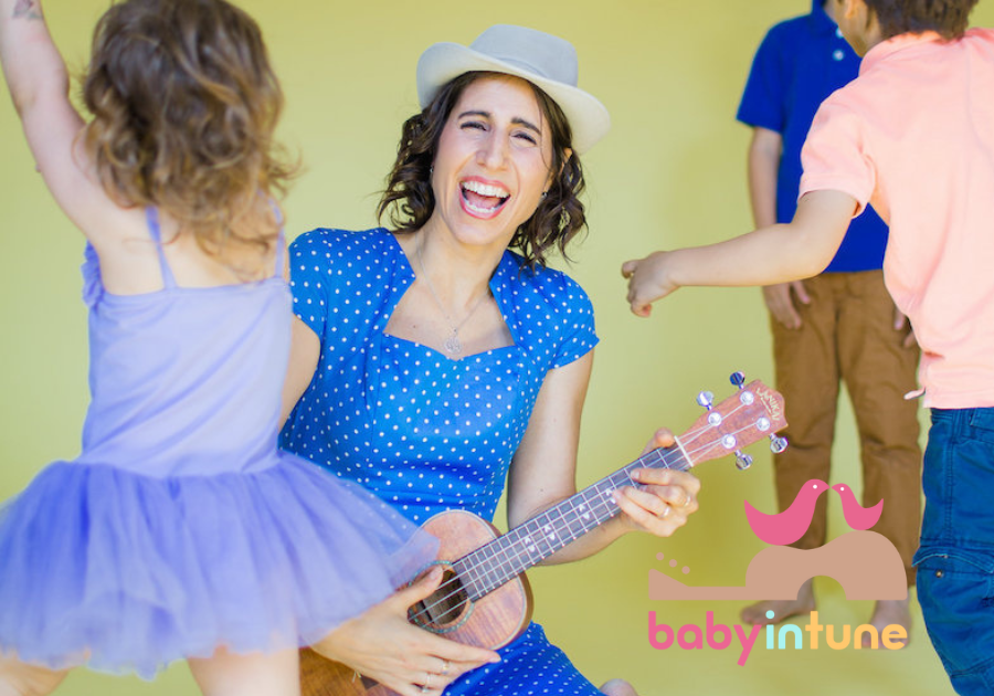 Musician, Vered singing and playing guitar with preschool children Musician, Vered singing and playing guitar with preschool children