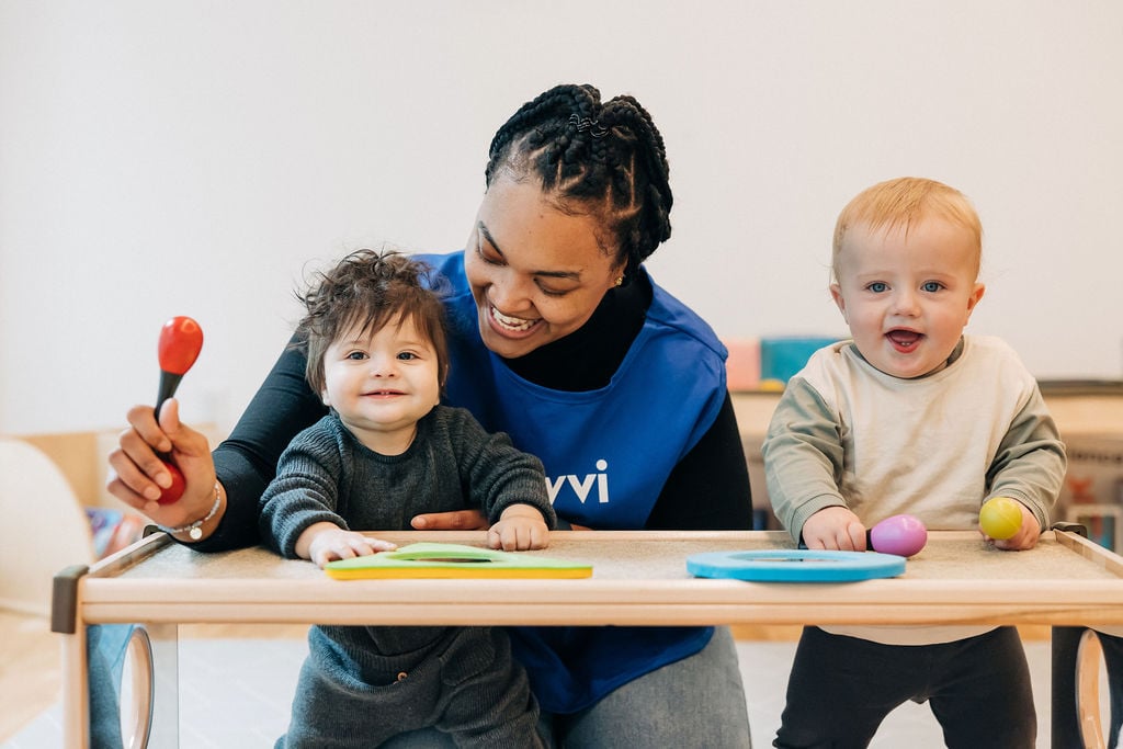 Teacher using musical instruments with two toddlers Teacher using musical instruments with two toddlers